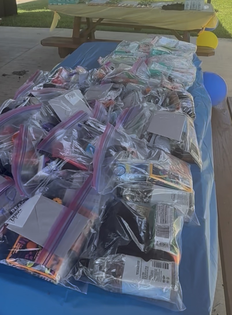 A table covered in donated food and supplies bagged and ready to hand out